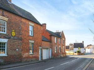 an old red brick building on a street at Amphlett Cottage in Bredon