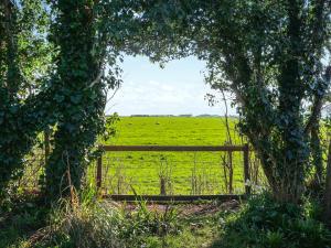 a gate in a field with a field with cows at Amphlett Cottage in Bredon
