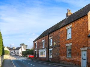 a brick building on the side of a street at Amphlett Cottage in Bredon +14 photos