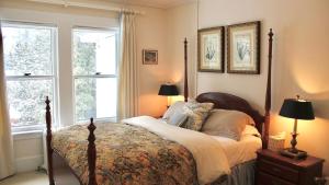 a bedroom with a bed and two windows at The Interlaken Inn in Lake Placid