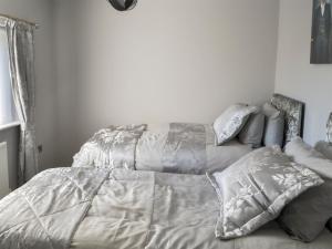 a bedroom with a bed with a gray comforter and pillows at Seashells By The Sea in Newbiggin-by-the-Sea