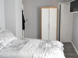 a bedroom with a white bed and a closet at Seashells By The Sea in Newbiggin-by-the-Sea