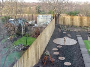 a garden with a wooden fence and a pond at Seashells By The Sea in Newbiggin-by-the-Sea +9 photos