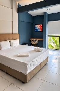 a bedroom with a large bed with blue walls at City Studios Apartamentos Novos em Natal in Natal