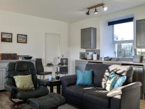 a living room with a couch and a chair at Cowar Bothy in Dalbeattie