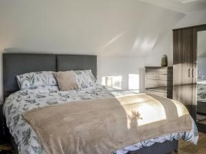 a bedroom with a large bed and a dresser at Cowar Bothy in Dalbeattie
