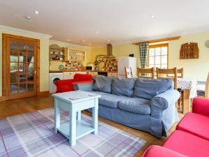a living room with a blue couch and a table at The Barn - S4593 in Lochearnhead
