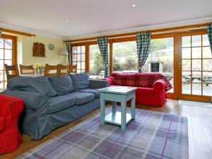 a living room with a couch and a table at The Barn - S4593 in Lochearnhead