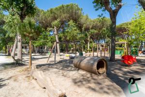 a park with a wooden playground with trees at Hotiday Lodge Viareggio in Viareggio