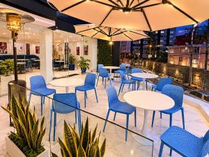 a restaurant with tables and blue chairs on a balcony at NIDO Boutique Hotel in Quito
