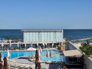 a swimming pool with umbrellas and the ocean in the background at Blu Mare Residense in Odesa