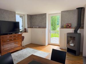 a living room with a television and a fireplace at Rustico Al Stradon by HolAp SA in Avegno