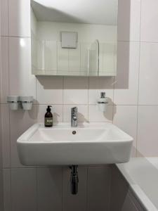 a white sink in a bathroom with a mirror at Rustico Al Stradon by HolAp SA in Avegno +17 photos