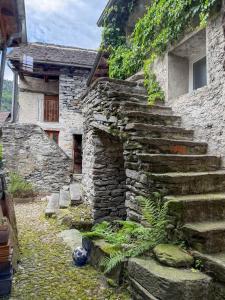an old stone house with stairs leading to a door at Rustico Al Stradon by HolAp SA in Avegno