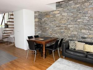 a dining room with a stone wall and a table and chairs at Rustico Al Stradon by HolAp SA in Avegno
