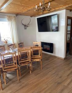 a dining room with a table and chairs and a tv at Casa Luna Șirnea in Şirnea