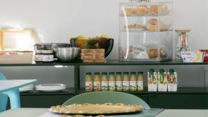 a table with a shelf of food and bottles of drinks at Dimora 5 Sensi in Pozzuolo del Friuli