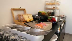 a kitchen counter with a sink and a shelf of food at Dimora 5 Sensi in Pozzuolo del Friuli