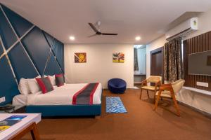 a bedroom with a bed and a desk and a tv at ABI RESIDENCY Hitech City in Hyderabad