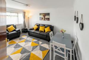 a living room with a couch and a table at Modern 2 BR ground floor apartment with parking and garden in Belvedere