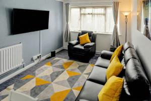 a living room with a couch and a flat screen tv at Modern 2 BR ground floor apartment with parking and garden in Belvedere