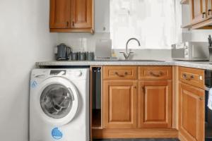 a kitchen with a washing machine and a sink at Modern 2 BR ground floor apartment with parking and garden in Belvedere +17 photos