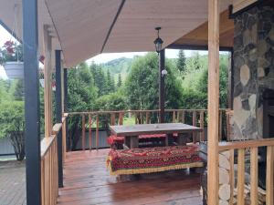 a wooden deck with a bench on a porch at Ватрич House in Chernivtsi