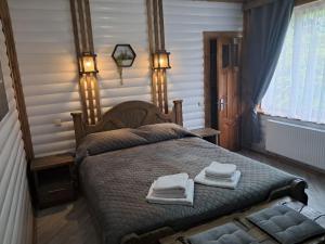 a bedroom with a bed with towels on it at Ватрич House in Chernivtsi +5 photos
