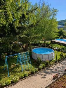 a swimming pool in a garden with a hot tub at Hotel Olimpiya in Balchik