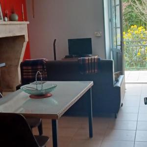 a living room with a couch and a table at Escale en sud Charente in Chavenat