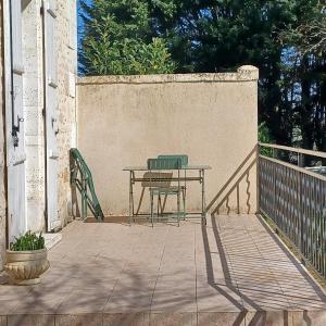 a table and a chair sitting on a patio at Escale en sud Charente in Chavenat +4 photos