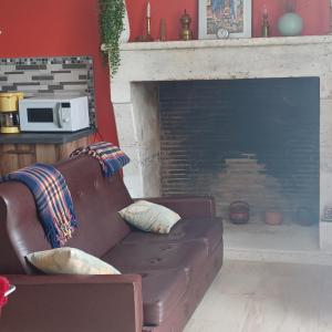 a living room with a couch and a fireplace at Escale en sud Charente in Chavenat