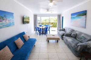 a living room with blue couches and a table at Chill-Ax Cottages in Port Shepstone