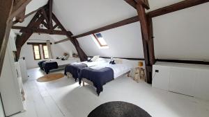 a bedroom with four beds in a room with wooden beams at Grandiflora in Saint-Julien-en-Born +24 photos