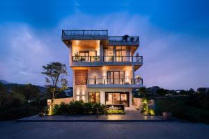 a tall building with a balcony on top of it at ArtLua Boutique Hotel Tam Coc in Văn Lâm