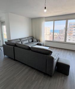 a living room with a large couch and large windows at Sea View Apartments in Durrës
