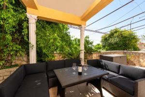 a patio with a black couch and a table at Apartman Miriam in Opatija