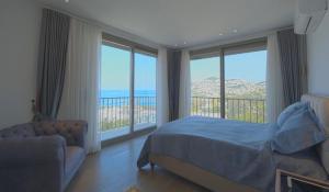 a bedroom with a bed and a view of the ocean at Gümüşlük Infinity Villa Seaview, Pool & Sauna in Bodrum City