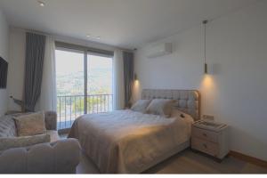 a bedroom with a bed and a large window at Gümüşlük Infinity Villa Seaview, Pool & Sauna in Bodrum City +19 photos