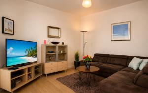 a living room with a couch and a flat screen tv at Ferienhaus Alisch Fewo 3 in Warnemünde
