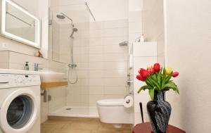 a bathroom with a washing machine and a vase of flowers at Ferienhaus Alisch Fewo 3 in Warnemünde +24 photos