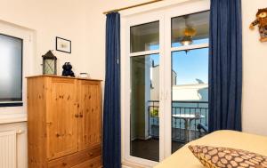a bedroom with a sliding glass door to a balcony at Ferienhaus Alisch Fewo 3 in Warnemünde