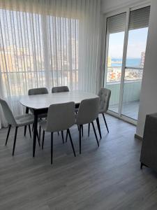 a table and chairs in a room with a large window at Sea View Apartments in Durrës