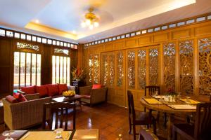 - un restaurant avec des tables et des chaises dans une salle dans l'établissement Lamphu Tree House Boutique Hotel, à Bangkok