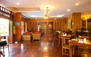um restaurante com mesas e cadeiras e um átrio em Lamphu Tree House Boutique Hotel em Bangkok