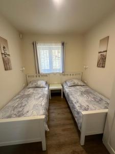 two beds in a small room with a window at Villa Sv. Martin in Mali Lošinj