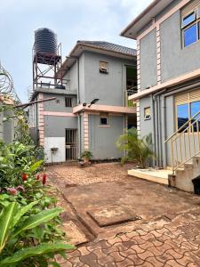 a house with a stone driveway in front of it at Zone hotel and guest house in Bugembe
