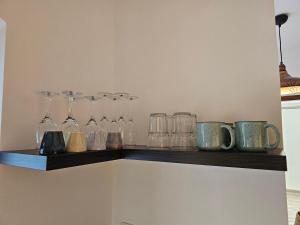 a shelf with glasses and mugs on it at Kapolcsi Kuckó in Kapolcs