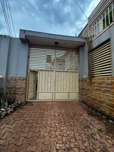 a house with two garage doors and a brick driveway at Zone hotel and guest house in Bugembe +9 photos