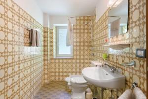 a bathroom with a white toilet and a sink at Rienznerhof Natureplace in Montagna